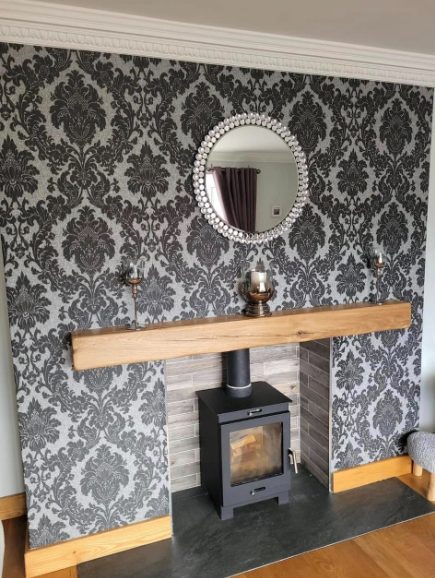 Log burner and oak mantel finished against a feature wall