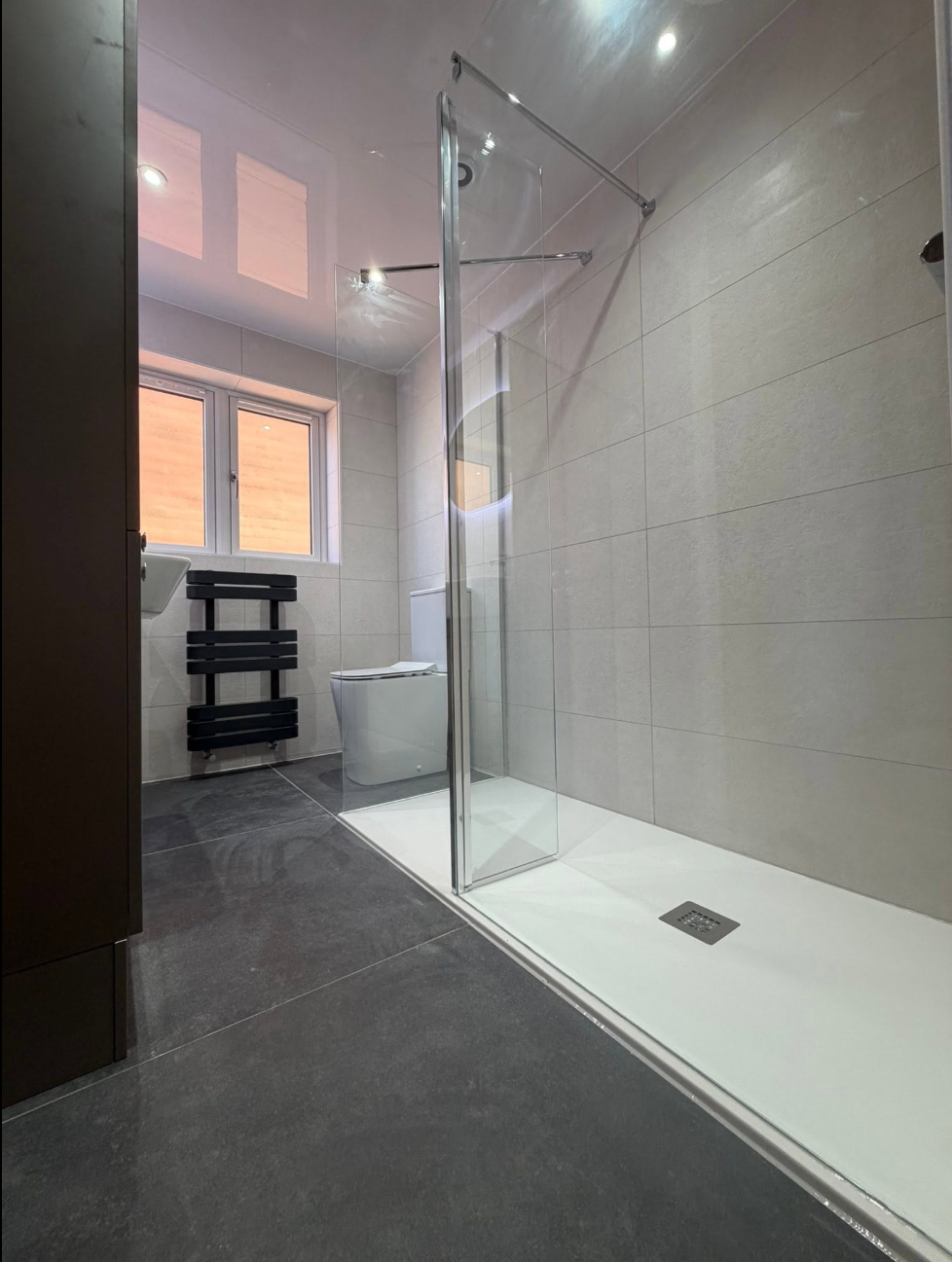 Walk-in shower with large-format tiling installed by SMS Services