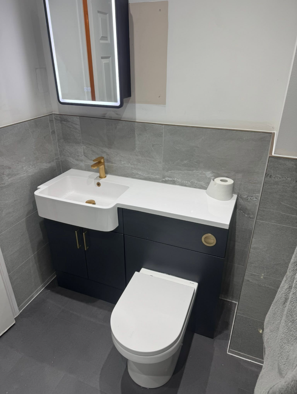 Navy vanity and WC combination unit with brushed brass fittings